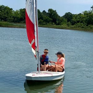 two in red sail boat