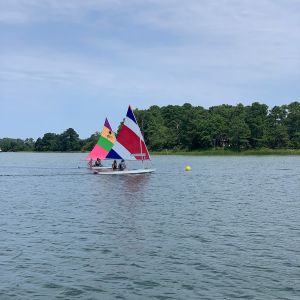 2 boats race toward yellow ball buoy