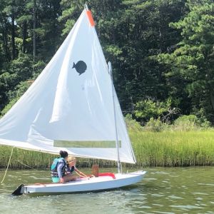 two campers in white boat near the shore